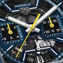 Close-up of a TAG Heuer Monaco Chronograph watch face, featuring hands, dials, gears, and the iconic TAG Heuer logo.