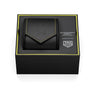 A black TAG Heuer Monaco Chronograph Racing Green watch case with yellow stitching rests inside a black box labeled TAG Heuer Monaco Chronograph Racing Green.
