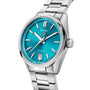 The TAG Heuer Carrera Date is a silver wristwatch with a teal blue dial, calibre 7 automatic movement, silver hour markers, date at 6 o’clock, and a stainless steel bracelet.