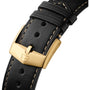 Close-up of the TAG Heuer Carrera Chronosprint x Porsche Rallyes black leather strap featuring beige stitching and a gold buckle engraved with a shield logo.