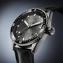 A close-up of the Blancpain Fifty Fathoms Bathyscaphe, featuring a black dial, rotating bezel, date display, and black fabric strap, powered by an automatic 1315 calibre movement.