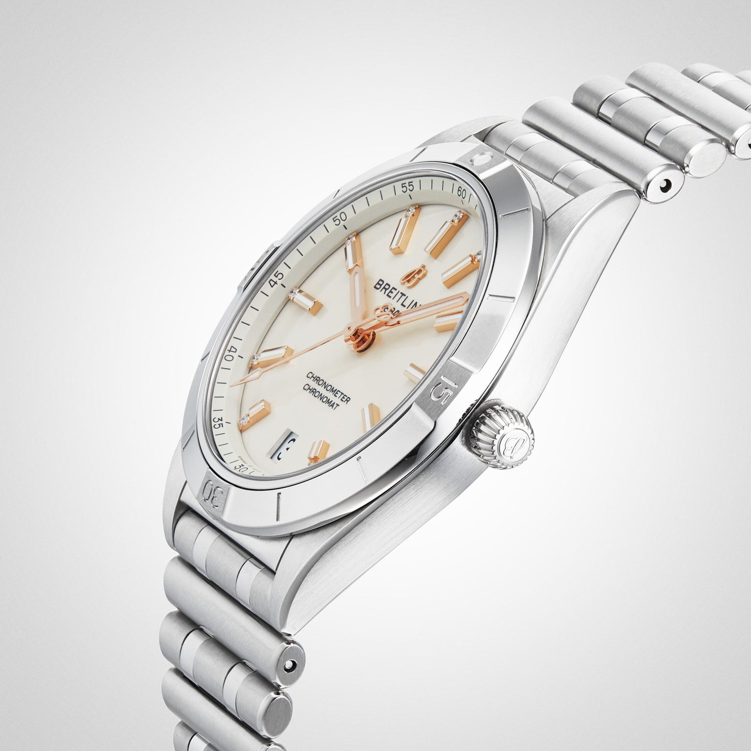 A Breitling Chronomat Automatic 36 wristwatch in stainless steel, featuring a white dial, rose gold hour markers and hands, and a signature Rouleaux bracelet, shown at an angle on a light background.