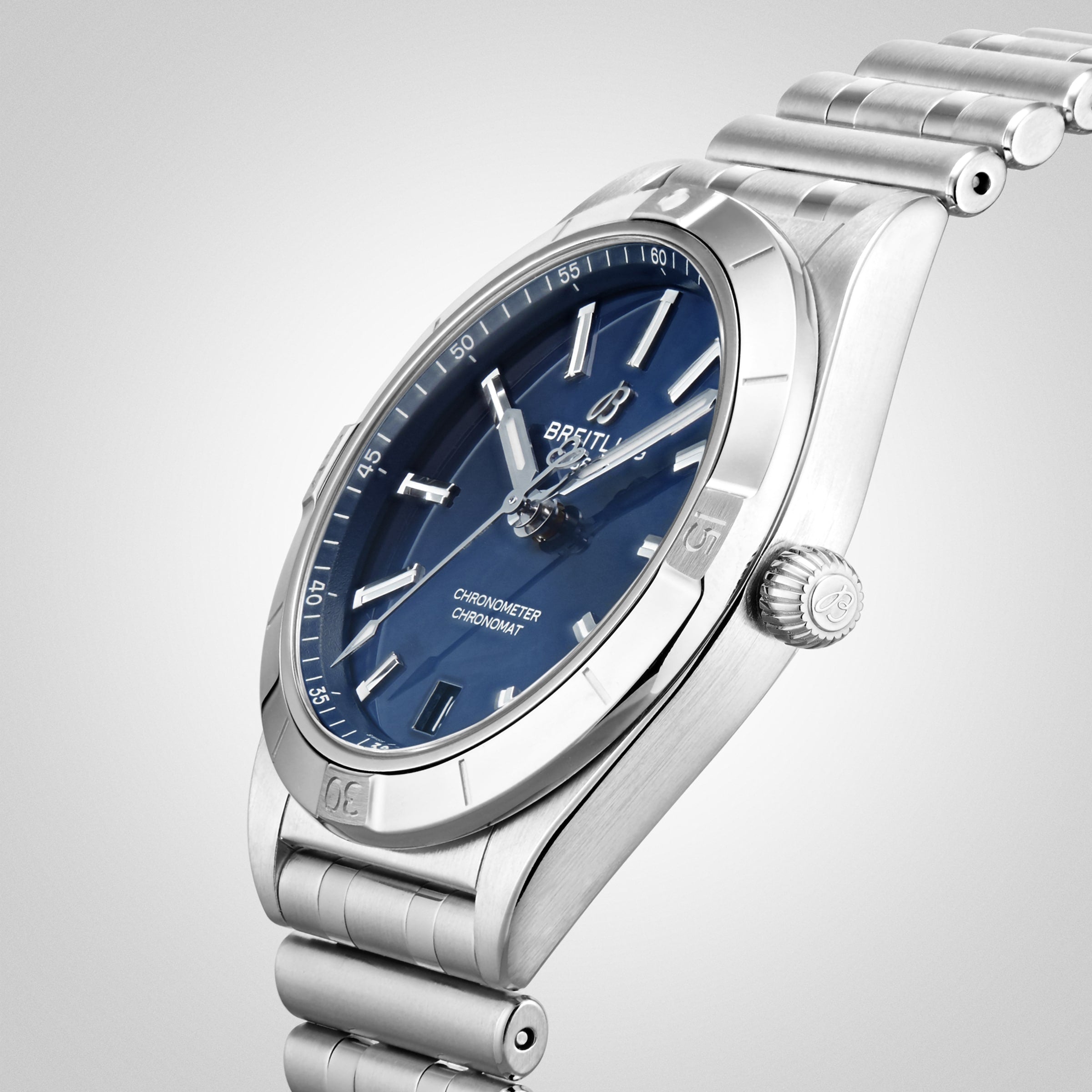 A silver Breitling Chronomat Automatic 36 wristwatch with a blue dial and metal bracelet, featuring the COSC-certified calibre, shown at an angle on a light gray background.