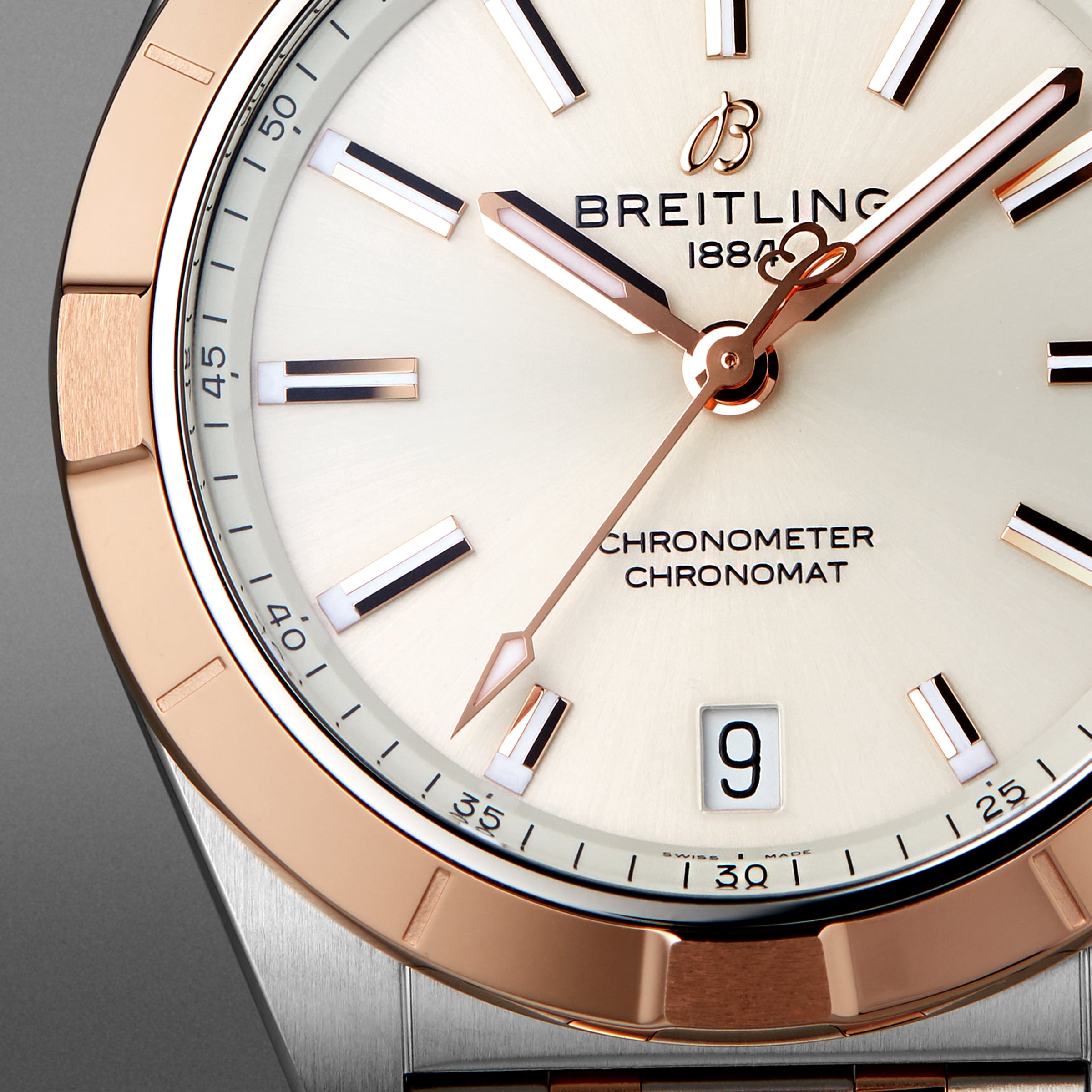 Close-up of the Breitling Chronomat 32’s face, showing gold-tone hands and markers, a date window at 6 o’clock, and Chronometer Chronomat on a light dial. COSC-certified.