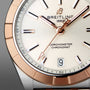 Close-up of the Breitling Chronomat 32’s face, showing gold-tone hands and markers, a date window at 6 o’clock, and Chronometer Chronomat on a light dial. COSC-certified.