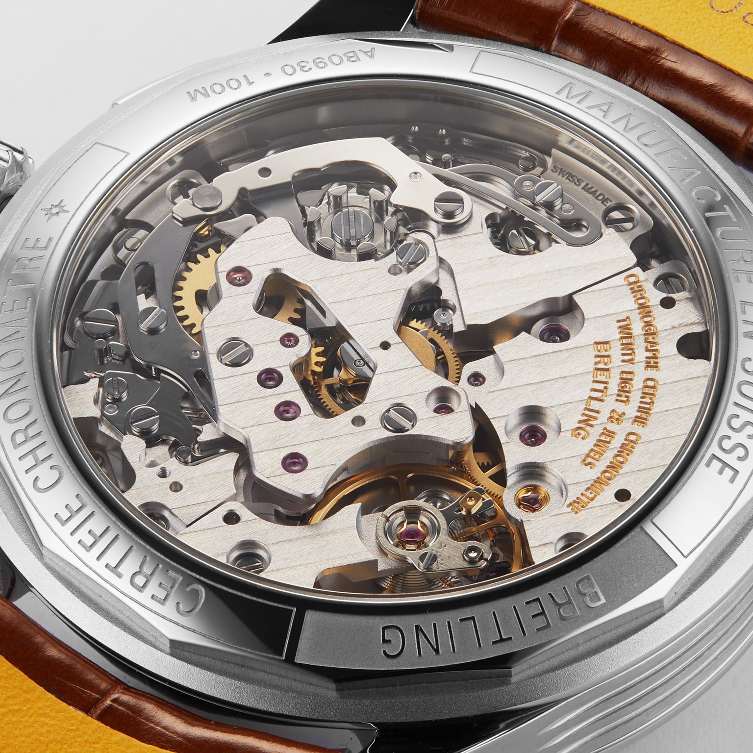Close-up view of the exposed B09 calibre movement inside the caseback of a Breitling Premier B09 Chronograph 40, revealing gears, screws, and intricate components.