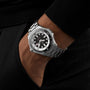 A person wearing a Breitling Superocean Automatic 46 with a black and white face inspired by the 1960s Slow Motion rests their hand in the pocket of black pants.