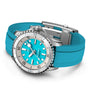 The Breitling Superocean Automatic 36 is a silver diving watch with a bright turquoise dial, matching rubber strap, large hour markers, and a ceramic inlayed rotating bezel.