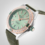 The Breitling Super Chronomat Automatic 38 is a luxury mechanical watch with a green dial, diamond-set bezel, rose gold accents, and green leather strap, powered by the Breitling 17 calibre and shown at an angle on a light background.