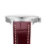 Side view of the Breitling Navitimer 32, featuring a silver case, textured bezel edge, and brown leather strap with white stitching, powered by the precise Breitling Calibre 77 SuperQuartz™ movement.