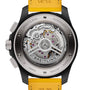 Close-up view of the back of a Breitling Avenger B01 Chronograph 44 Night Mission, featuring its exposed Breitling 01 calibre movement, labeled components, and a distinctive yellow leather strap.