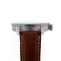 Side view of the Breitling Navitimer Automatic GMT 41, showcasing its 41mm stainless steel case, textured bezel, crown, and brown leather strap with white stitching inspired by classic aviator style.