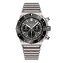 The Breitling Super Chronomat B01 44 is a stainless steel chronograph watch with a black bezel, three subdials, tachymeter markings, and a metal bracelet, powered by the precise Breitling 01 calibre and shown against a white background.