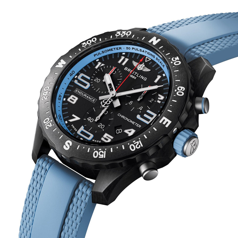 The Breitling Endurance Pro 38 is an athleisure watch with a black dial, blue bezel, light blue textured rubber strap, multiple subdials, white markings, and an ultra-lightweight Breitlight case.