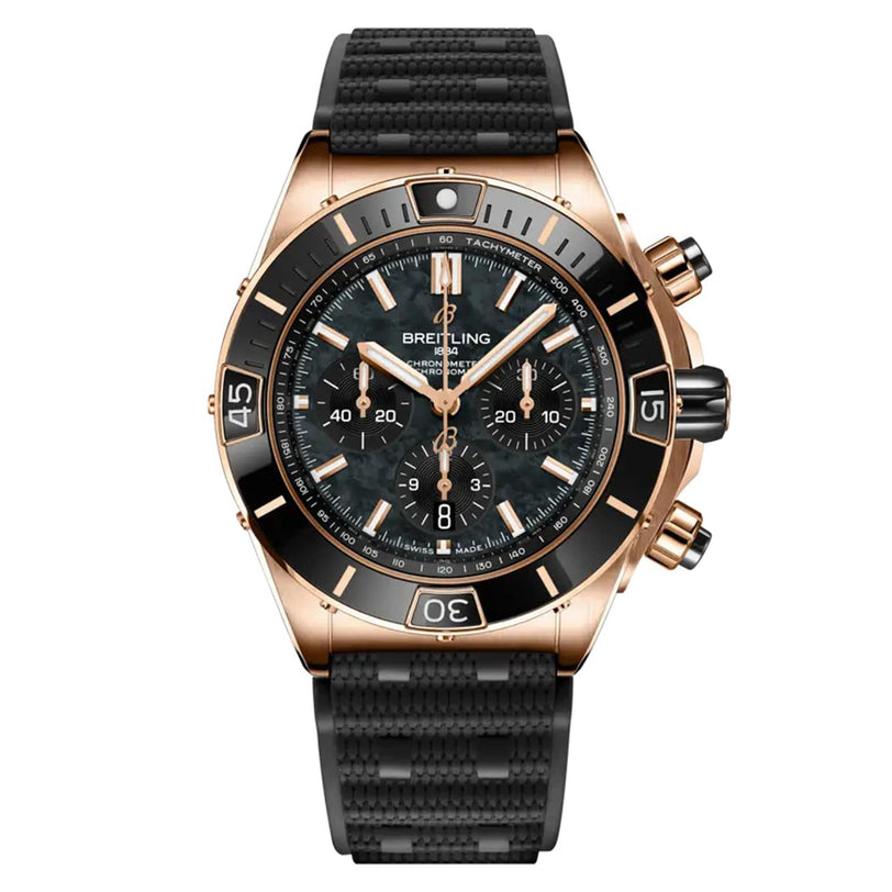 The Breitling Super Chronomat B01 44 features a black dial with gold markers, three subdials, and a black textured rubber strap—this COSC-certified chronometer blends precision with bold style.