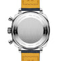 A close-up of the back of the Breitling Top Time B01 Racing wristwatch shows a brushed metal case, two buttons, engraved text, and a two-tone leather strap—a true homage to racing-inspired chronographs.