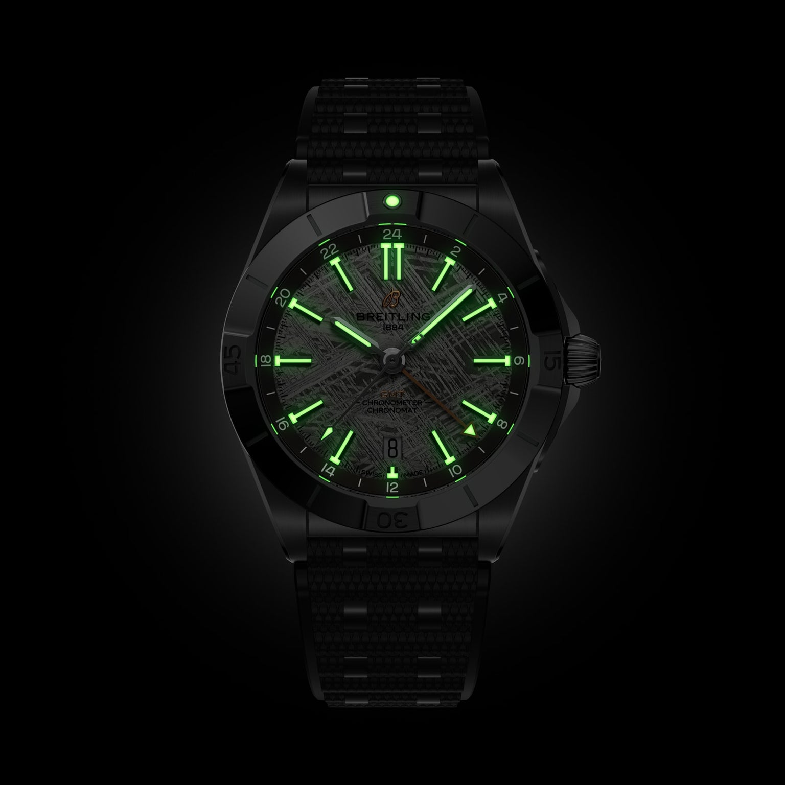 The Breitling Chronomat Automatic GMT Erling Haaland features green glowing hands and hour markers, showcased on a dark background.