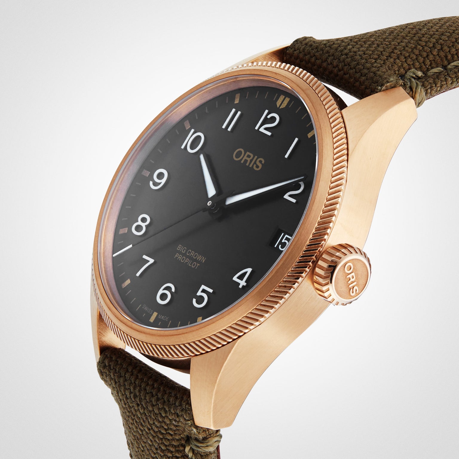 Oris Big Crown ProPilot Big Date wristwatch in bronze with a black dial, white numerals, and an olive green fabric strap, shown from an angled perspective.