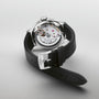 The Oris Big Crown Pointer Date Calibre 403 wristwatch with a black leather strap is displayed face down, revealing its intricate movement and inner workings, with Oris engraved on the buckle.