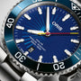 Close-up of the Oris Aquis Sun Wukong Limited Edition watch, featuring a blue dial, white markers, date window at 6 oclock, and stainless steel bezel and bracelet.