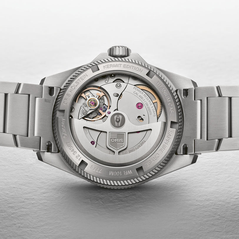 Close-up of the Oris ProPilot X Kermit Edition watch, featuring its exposed mechanical movement and engraved details on the stainless steel case and bracelet.