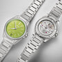 Two Oris ProPilot X Kermit Edition stainless steel wristwatches are shown: one displays a green dial, while the other reveals its Oris Calibre 400 movement through a transparent case back.