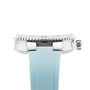 Side view of the Oris Aquis Date diver’s watch featuring a silver bezel and crown, paired with a light blue strap, highlighting its high-performance profile against a white background.