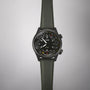 The Oris ProPilot Altimeter wristwatch, featuring a multi-colored dial and an olive-green woven strap, is shown against a plain light background.
