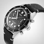 The Oris Divers Sixty‑Five Chronograph, featuring a black and silver design with a black leather strap, shown from an angled perspective.