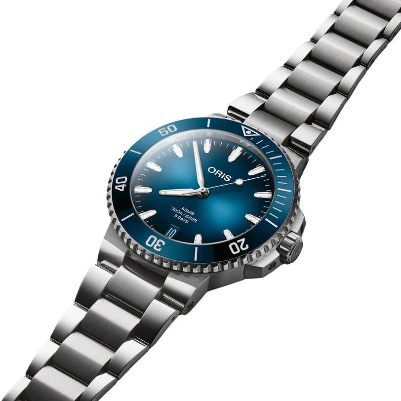 An Oris Aquis Date Calibre 400 stainless steel wristwatch with a blue dial and silver bracelet, displayed at an angle.