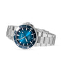 An Oris Aquis Date Calibre 400 stainless steel watch with a blue dial, silver markers, and metal bracelet is shown angled on a white background. The Oris brand is visible on the face of this mechanical diving timepiece.