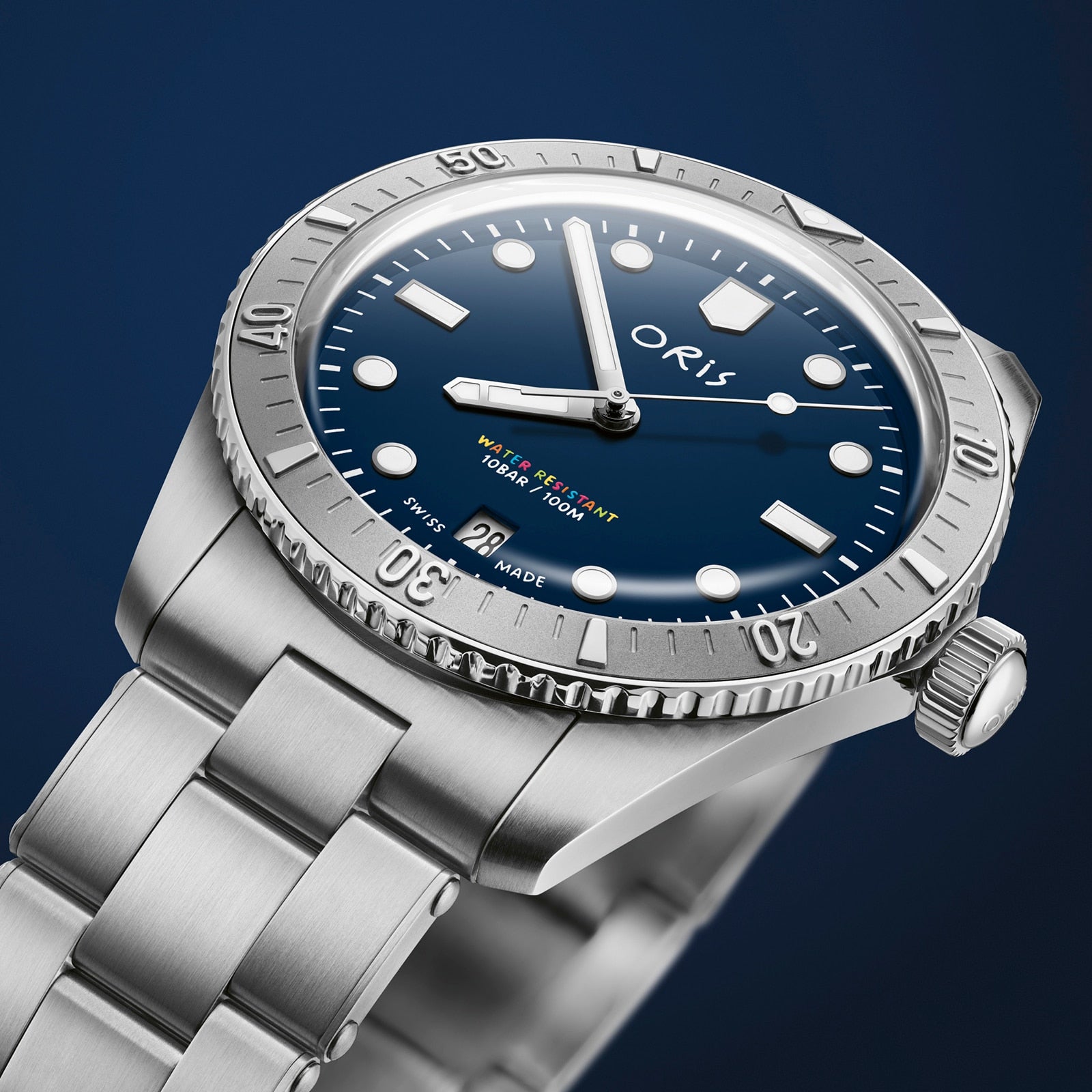 The Oris LFP Limited Edition is a stainless steel wristwatch with a blue dial, rotating bezel, and metal bracelet, shown against a dark blue background—created to celebrate the Ligue de Football Professionnel.
