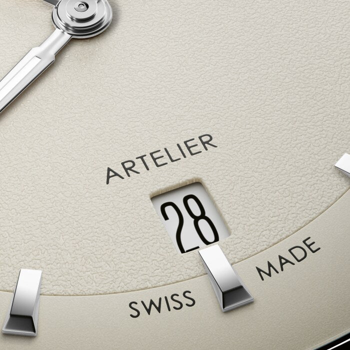 Close-up of a watch face with 'Artelier' and 'Swiss Made' text.