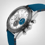 A close-up of the Zenith Chronomaster Sport wristwatch featuring a blue strap, silver case, black bezel, and three subdials in grey, blue, and silver on a white dial highlights its iconic automatic chronograph movement.