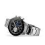 The Zenith Chronomaster Sport is a stainless steel chronograph wristwatch with a black bezel, three subdials, and a metal link bracelet, displayed at an angle on a white background.
