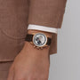 A man in a brown suit and white shirt with the Chronomaster EP Original on wrist