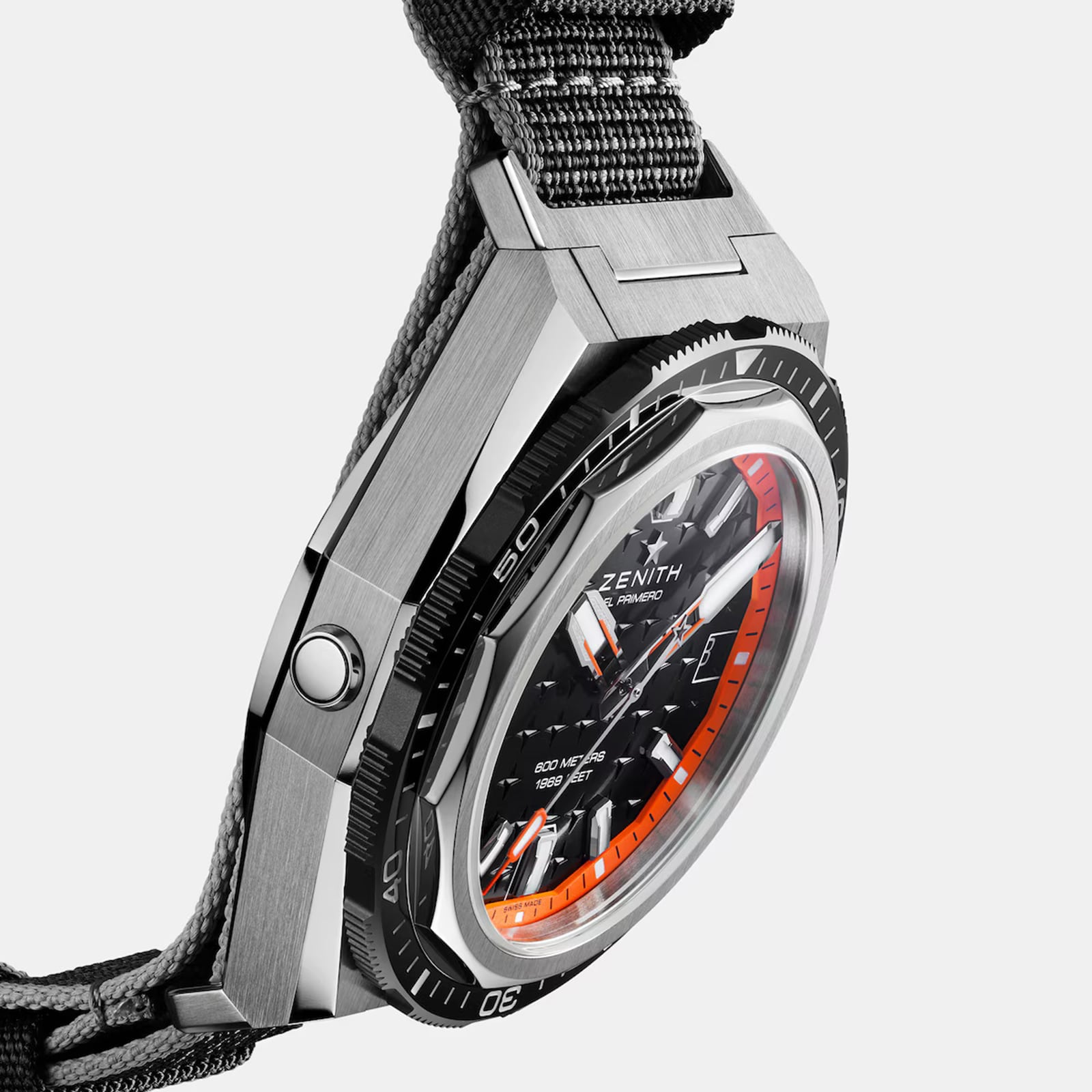 Close-up of the Zenith Defy Extreme Diver wristwatch featuring a black and orange dial, angular titanium case, automatic movement, and textured fabric strap set against a white background.