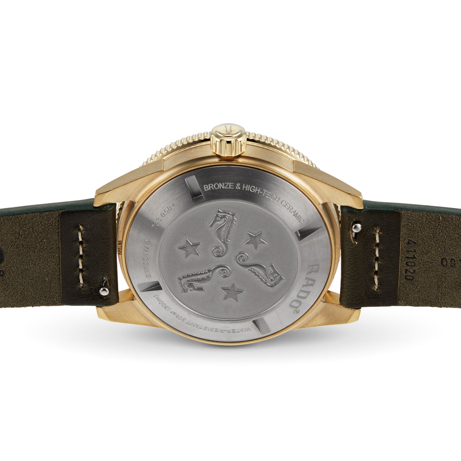 Back view of the Rado Captain Cook Automatic Bronze, showcasing its bronze case and engraved metal case back with seahorses, stars, technical details, and a green leather strap.