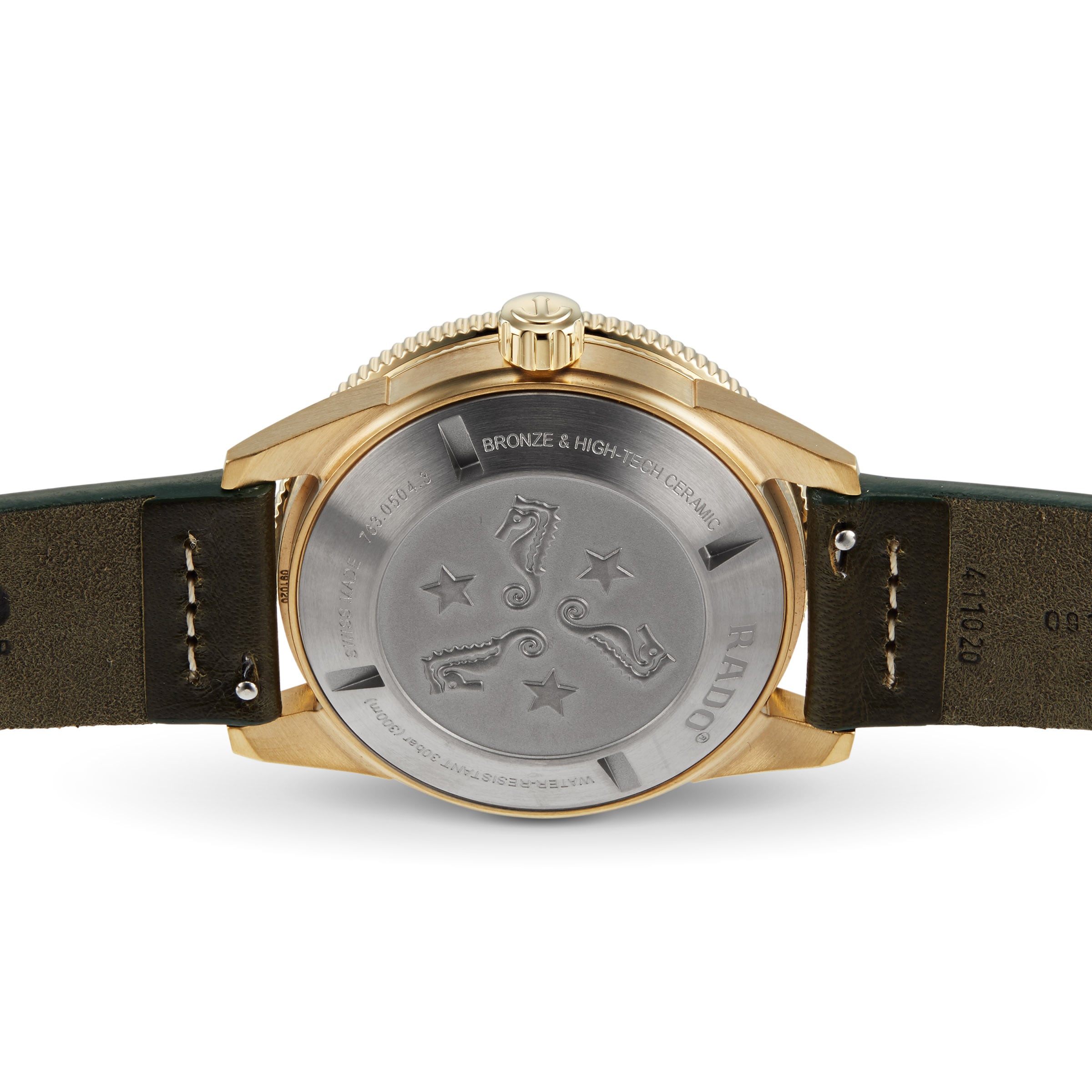 Back view of the Rado Captain Cook Automatic Bronze, showcasing its bronze case and engraved metal case back with seahorses, stars, technical details, and a green leather strap.