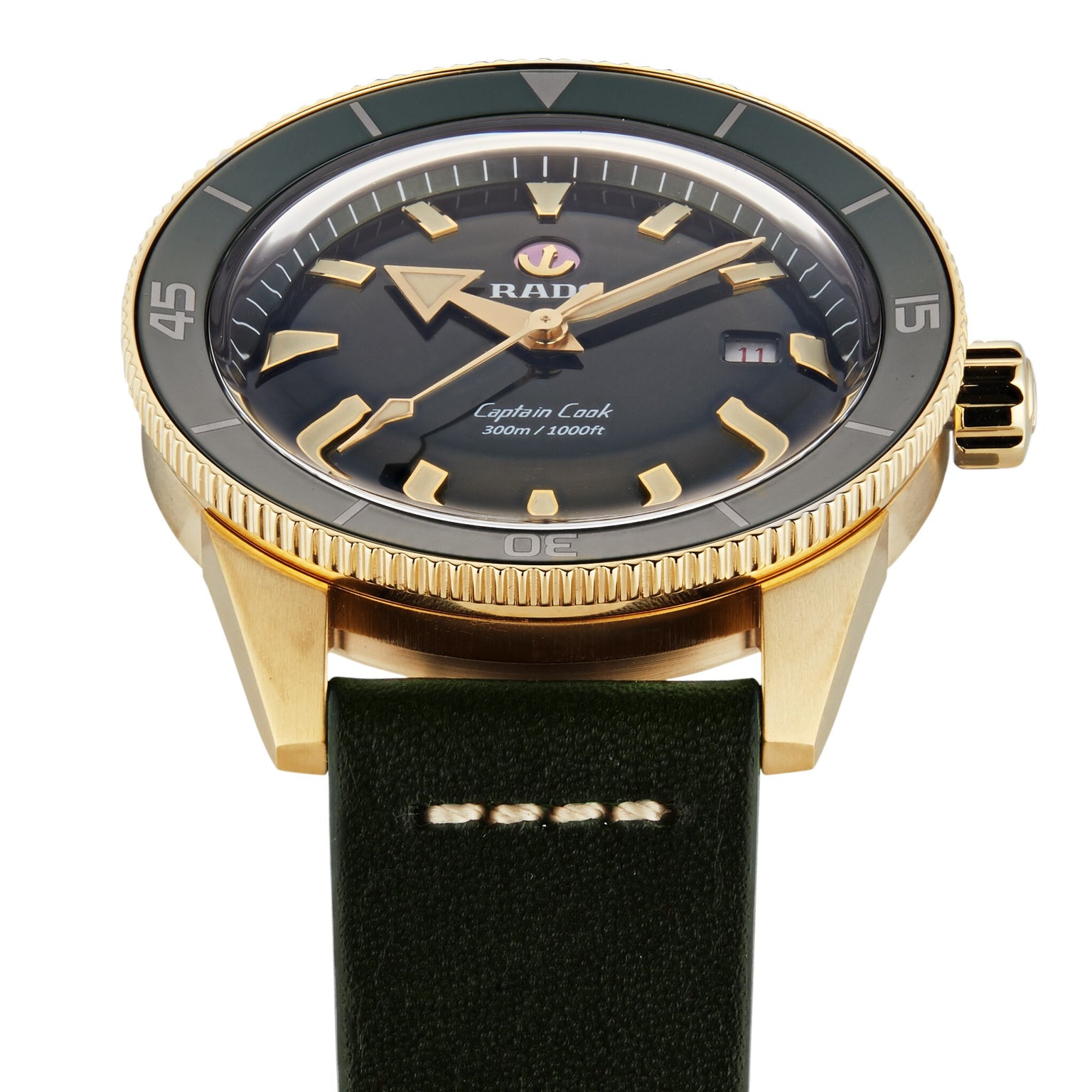The Rado Captain Cook Automatic Bronze features a gold-tone bronze case, dark green bezel, black dial, and green leather strap, displayed here showing the time as 1:40.