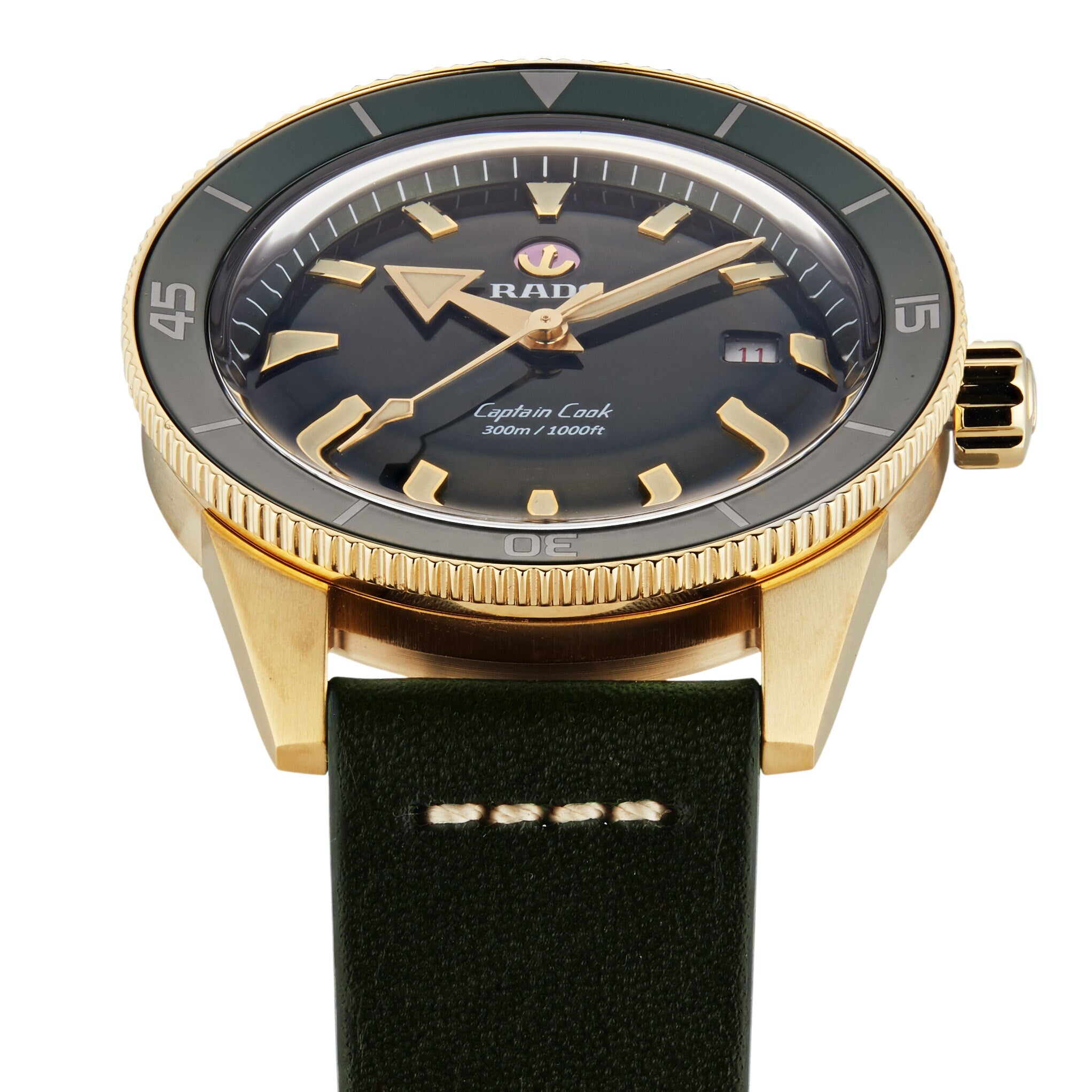 The Rado Captain Cook Automatic Bronze features a gold-tone bronze case, dark green bezel, black dial, and green leather strap, displayed here showing the time as 1:40.