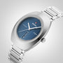 A Rado DiaStar Original wristwatch with a blue oval dial, date display, scratch-resistant sapphire crystal, and stainless steel bracelet is displayed on a light gray background.