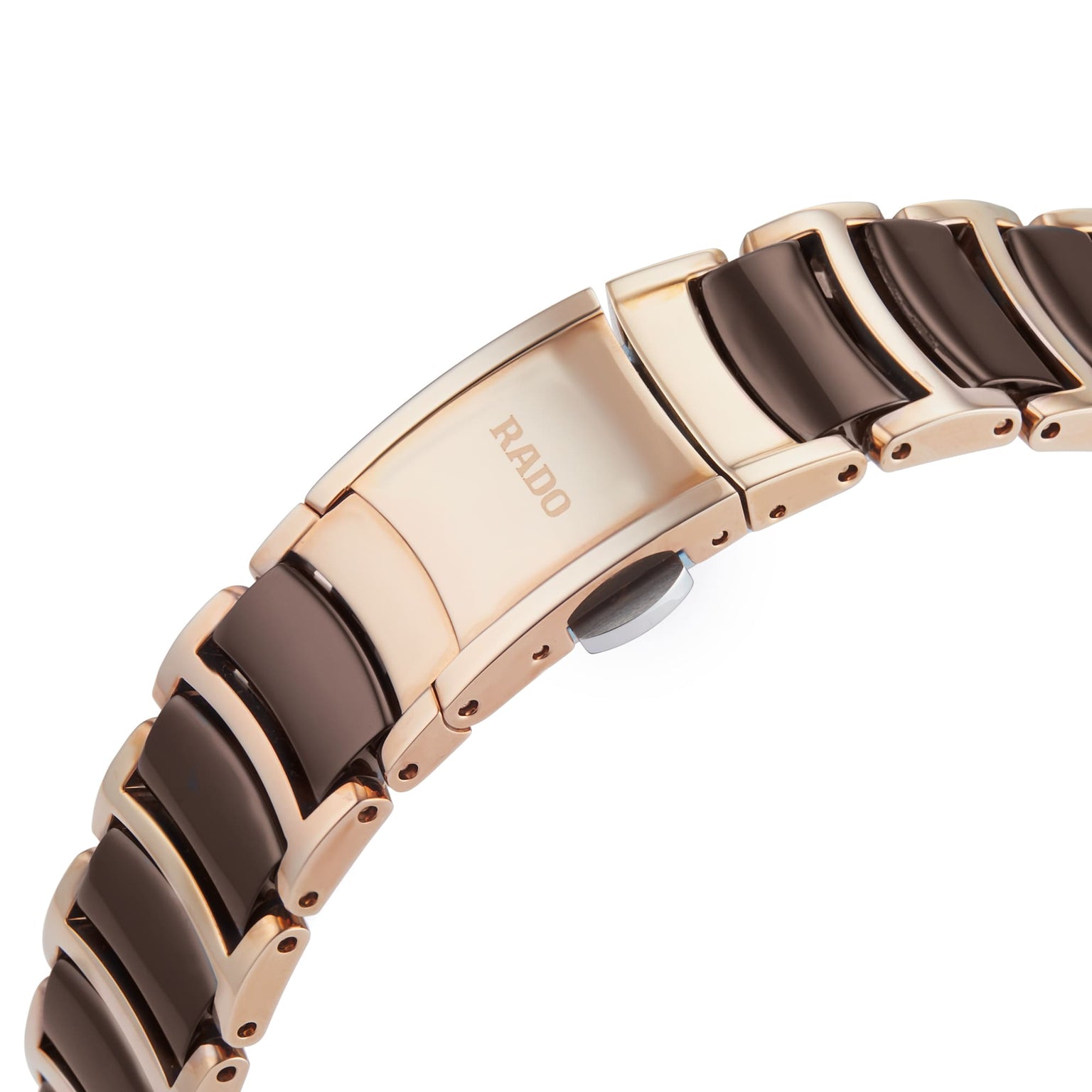 Close-up of a Rado Centrix watch bracelet, showcasing rose gold and black ceramic links with the Rado logo engraved on the clasp.