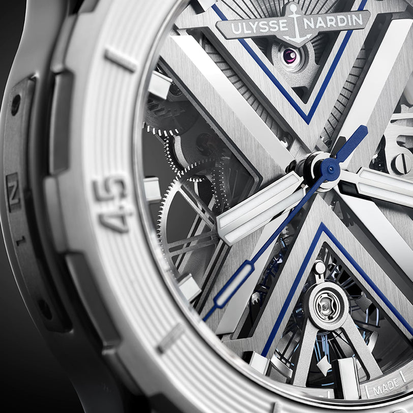 Close-up of the Ulysse Nardin Diver X Skeleton, showing its open-worked dial with visible gears, blue accents, bold hour and minute hands, all set in a sleek titanium case.