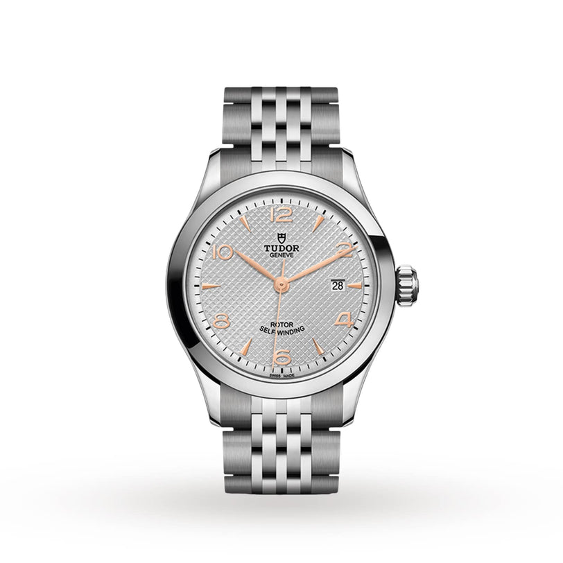 A TUDOR 1926 silver ladies’ wristwatch featuring a textured light gray dial, gold hour markers, self-winding movement, date at 3 o’clock, and metal link bracelet shown on a white background.