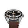 The TUDOR Black Bay 58 is a vintage-inspired stainless steel wristwatch with a black bezel, black dial, luminous markers, and a brown leather strap, reminiscent of classic diving watches, shown from the front.