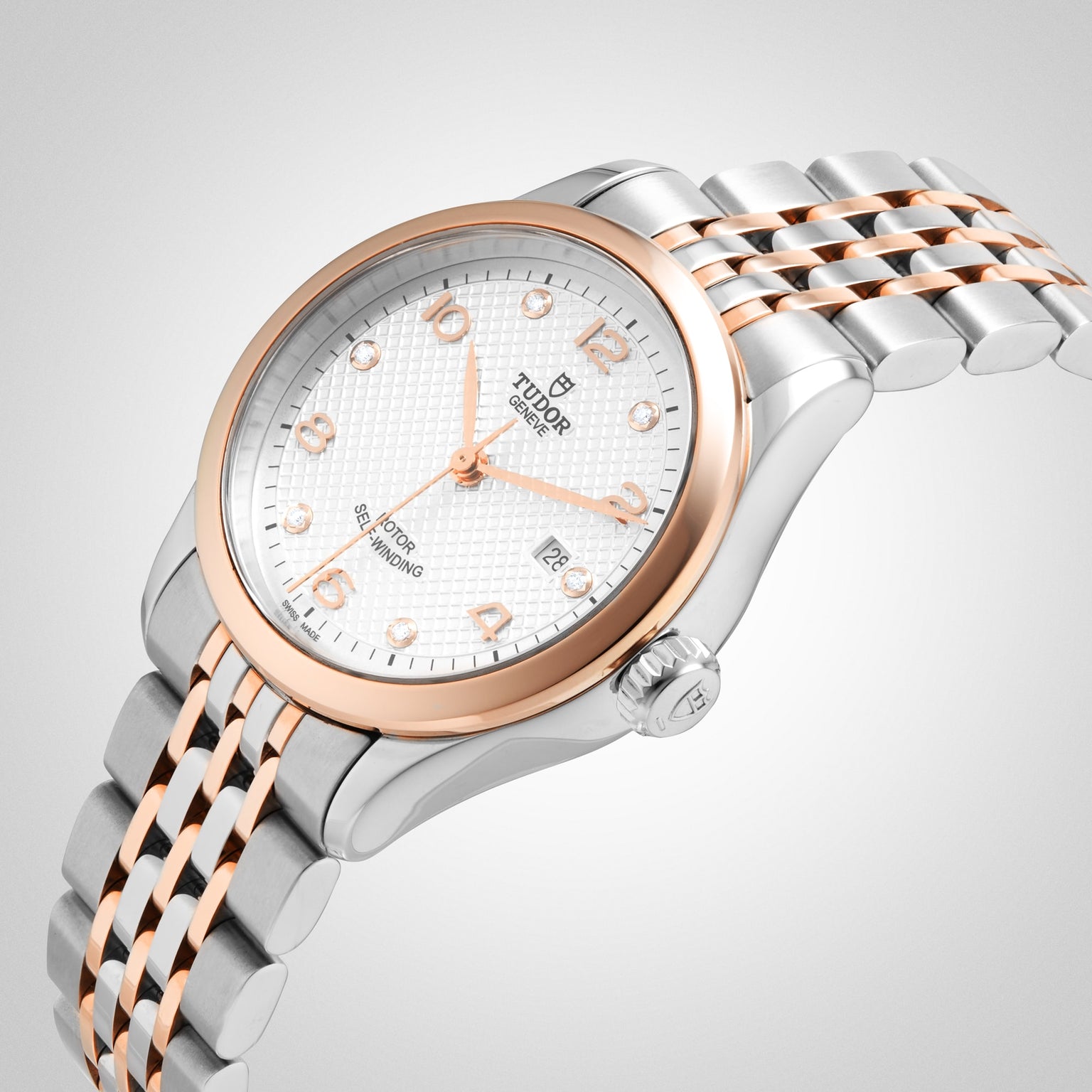 The TUDOR 1926 features a white textured dial, gold and silver stainless steel bracelet, rose gold bezel, date display, silver hour markers, and is powered by the precise mechanical caliber 2671 movement.