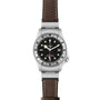 The TUDOR Black Bay P01 is a stainless steel wristwatch featuring a black dial, snowflake hands, white hour markers, a date window at 3 o’clock, and a brown leather strap.