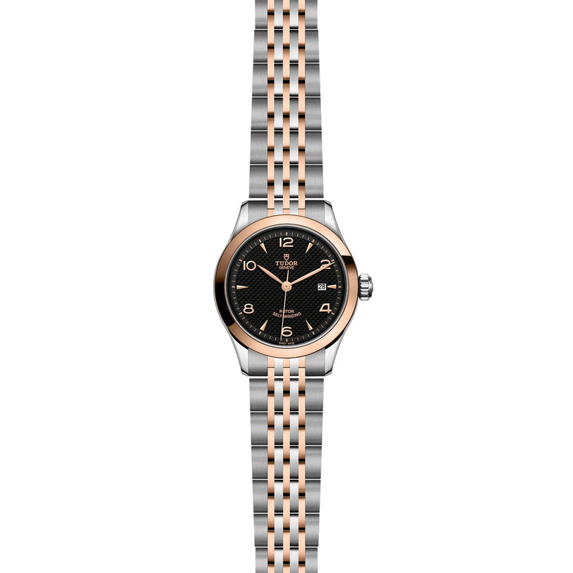 The TUDOR 1926 is a classic, elegant two-tone wristwatch with a black dial, gold hour markers, date display, and a silver and rose gold link bracelet—ideal for fine mechanical watch enthusiasts.