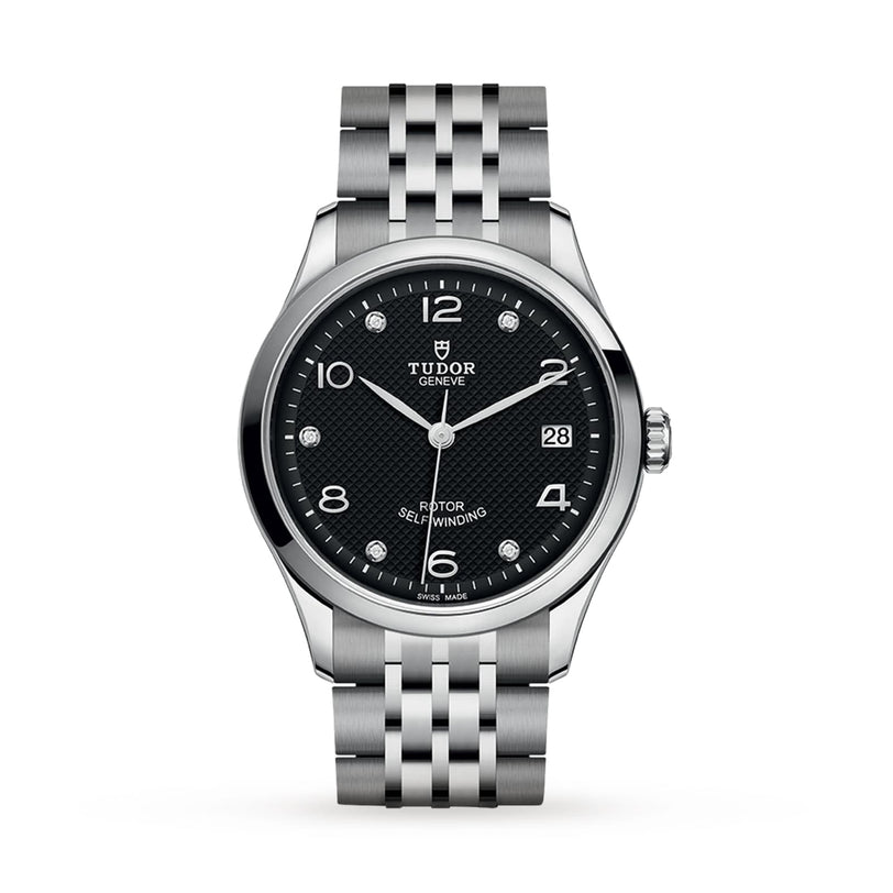 A TUDOR 1926 stainless steel wristwatch featuring a black textured dial, silver hour markers, date display at 3 o’clock, and a metal link bracelet is displayed on a white background.